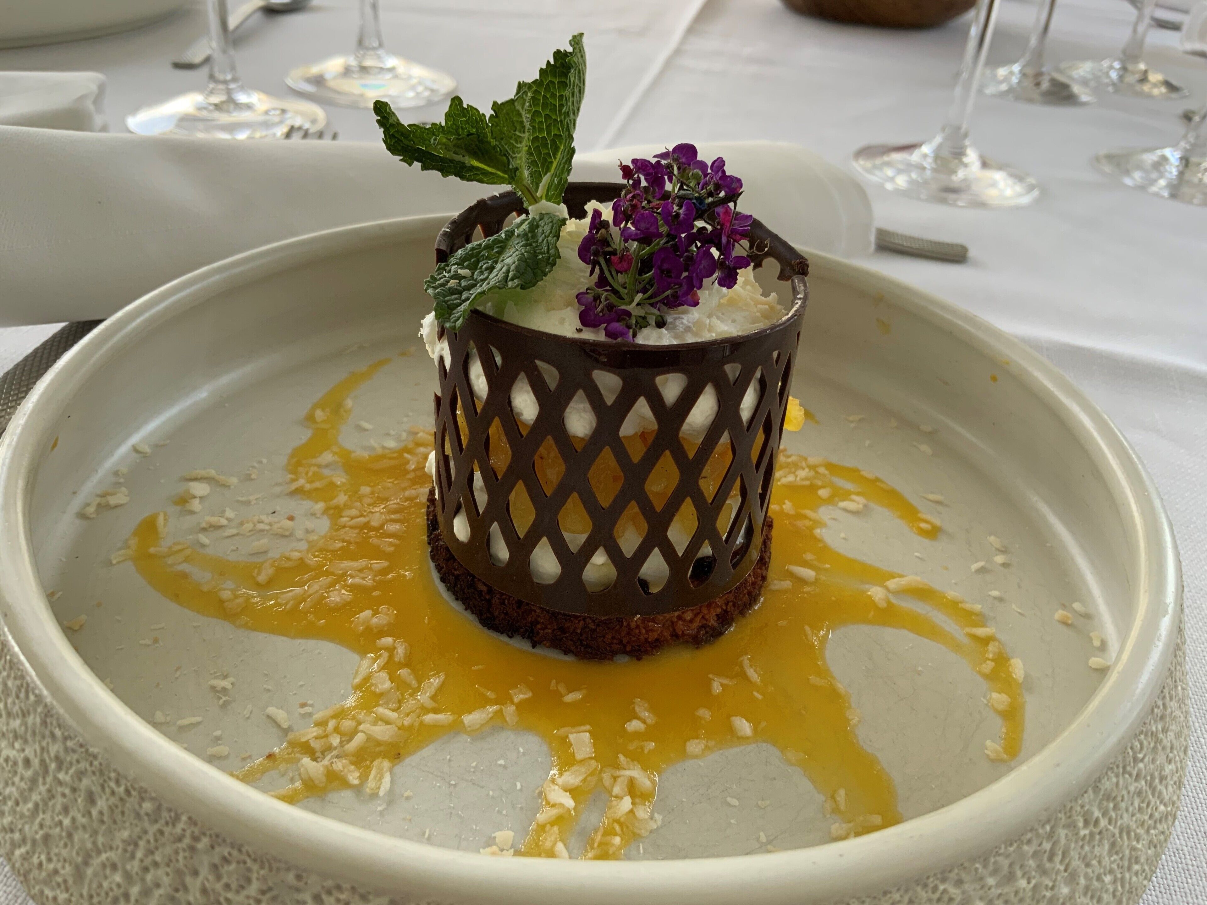A dessert with a lattice design, served on a white plate with a golden sauce.
