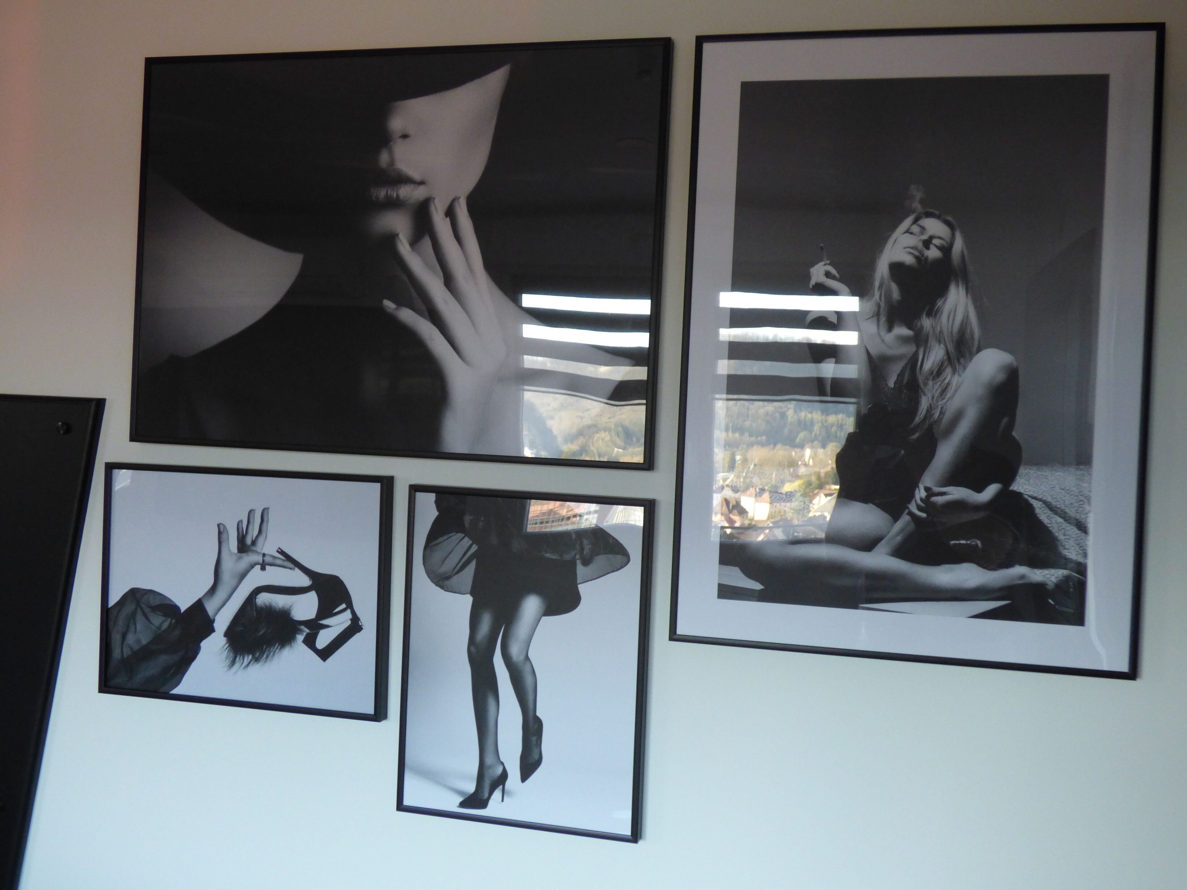 A wall with four framed photographs.