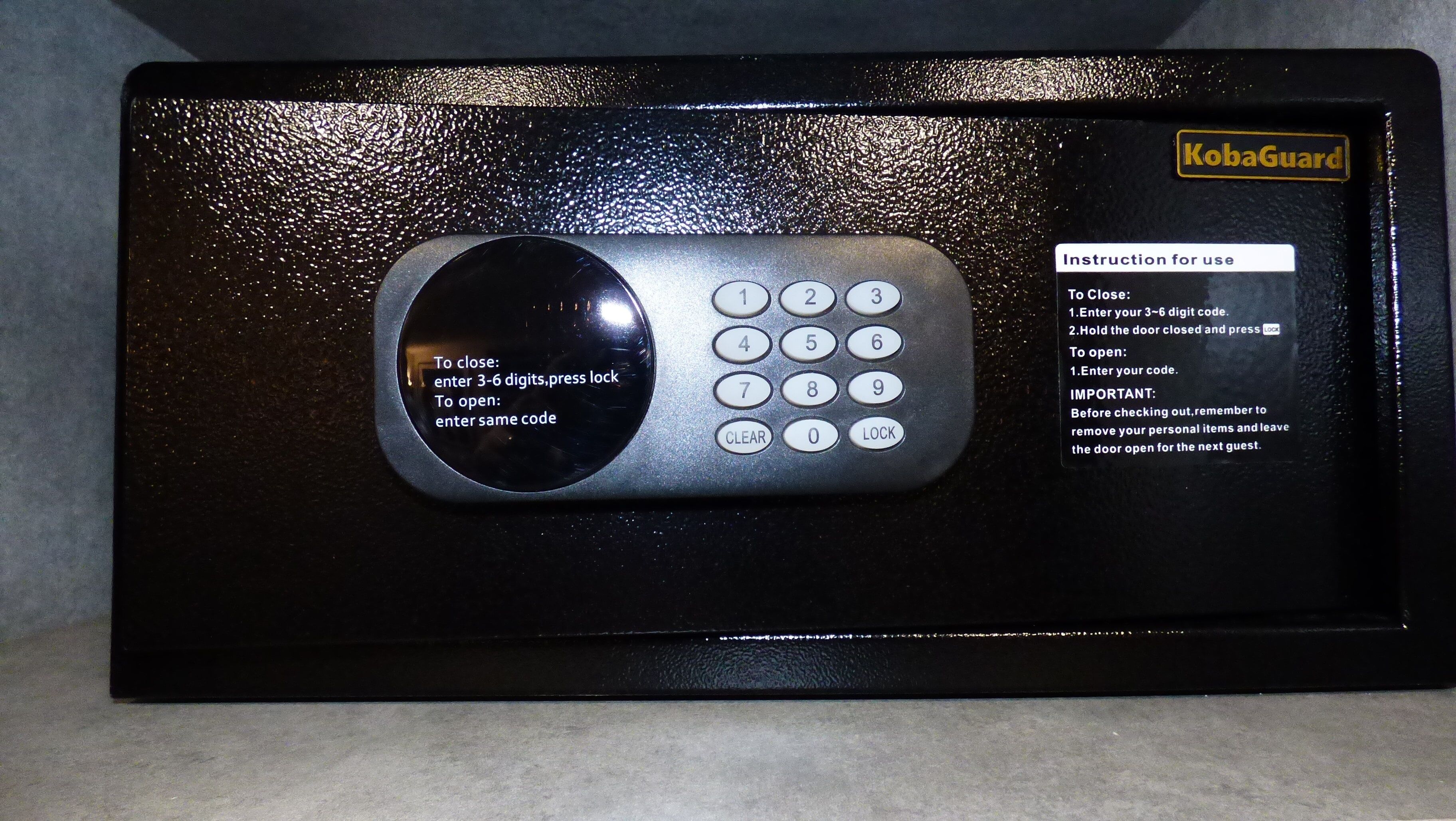 A KobaGuard electronic keypad with instructions for use, including entering a 3-6 digit code to lock or unlock.