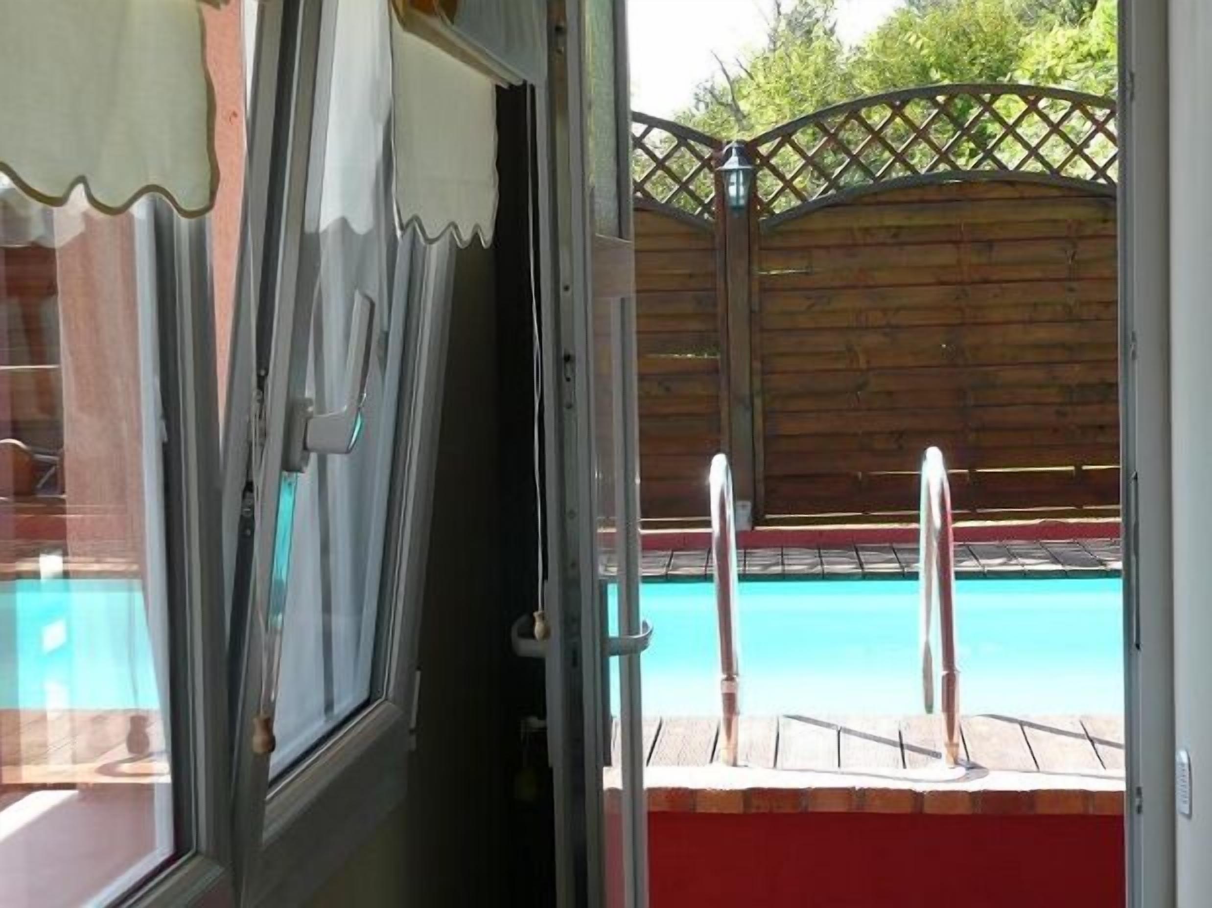 A pool area with a wooden fence and a view of the pool.