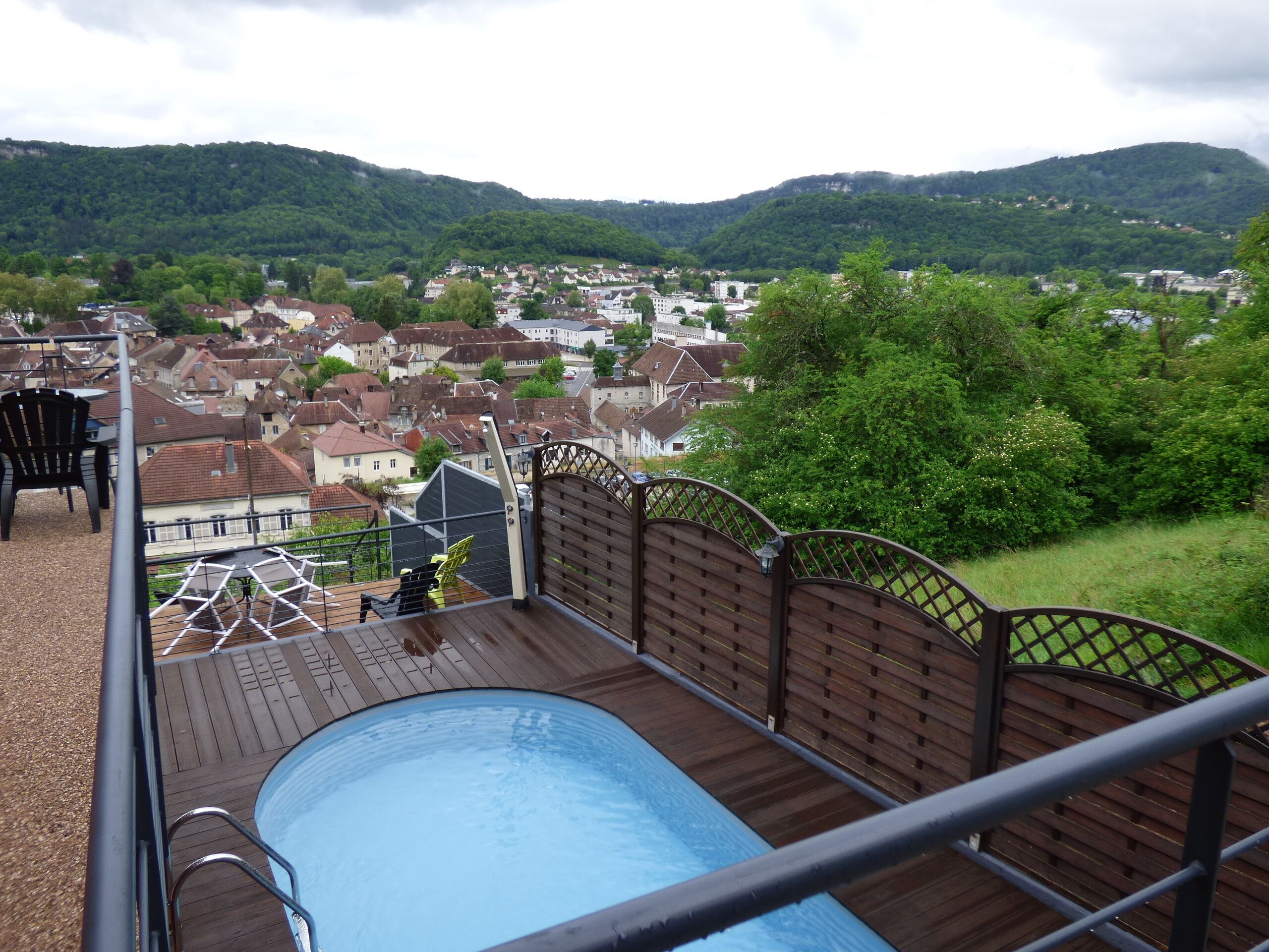 A pool area with a view of a town and hills in the background.