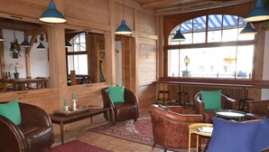 Un interior acogedor con paredes de madera, muebles de cuero y ventanas amplias.