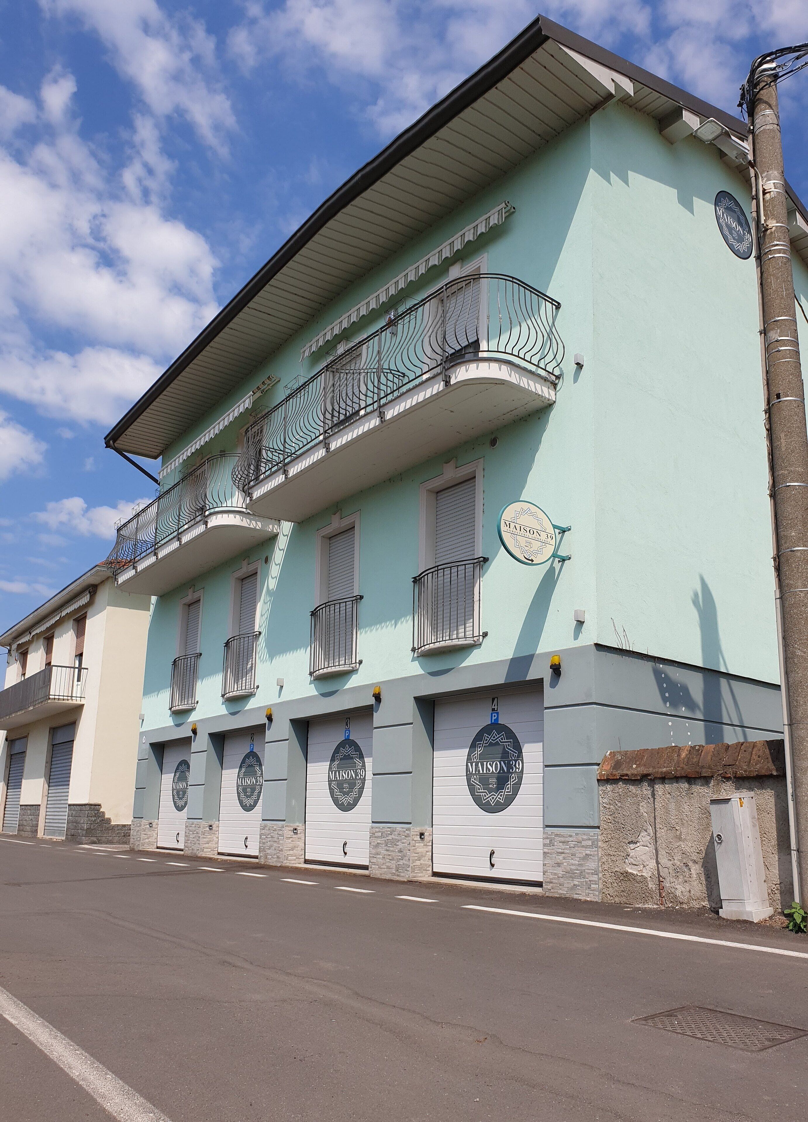 A two-story building with balconies and a sign indicating 'MAISON 39'.