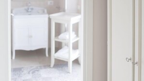 A bathroom with a white vanity, a round mirror, and a white cabinet. -  Gruppo Luxe Domus (Vigevano)