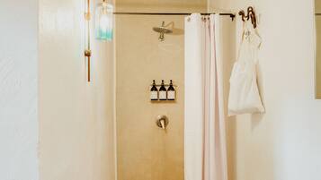 Ein Badezimmer mit Dusche, Handtuchhalter und einer Duschkabine aus Glas.