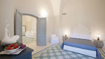 Een slaapkamer met een bed, een kaptafel, een stoel en een tafel met fruit.