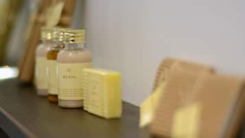 A bathroom shelf with toiletries including a bottle labeled 'ELSYL' and a bar of soap.
