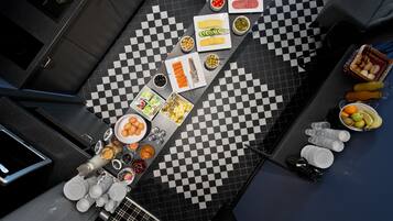 A kitchen with a checkered floor, various food items, and kitchenware.