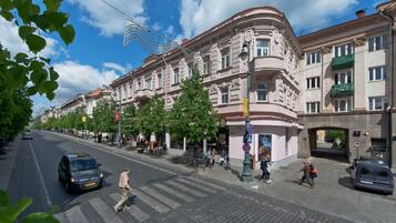 Una calle con edificios, peatones y vehículos.