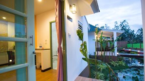 Un interior moderno con cocina, baño y vista a un estanque.