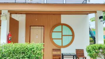 A modern building entrance with a wooden facade, a circular window design, and a sign offering a discount for AIS TOURIST.