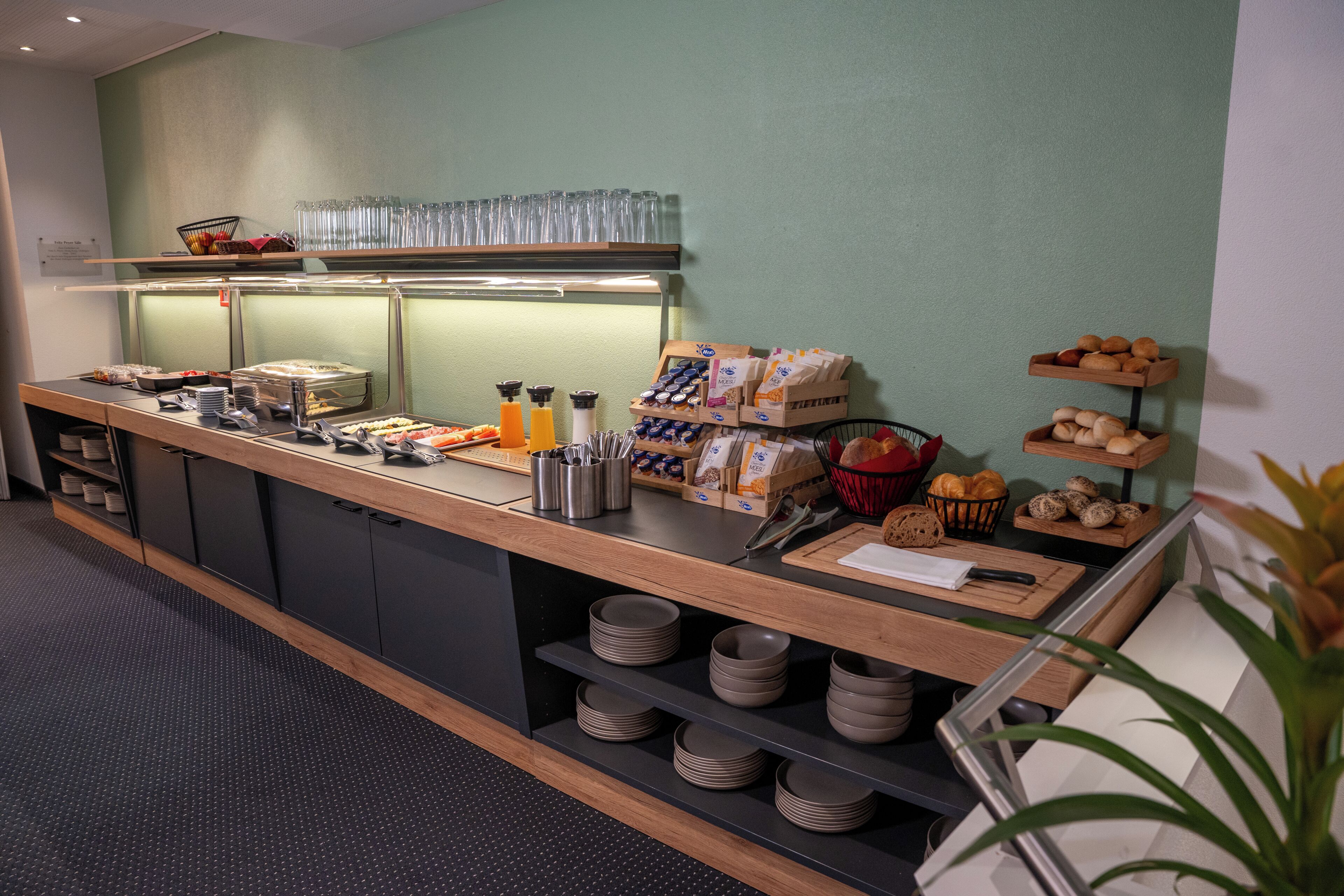 A buffet setup with various food items, utensils, and condiments.