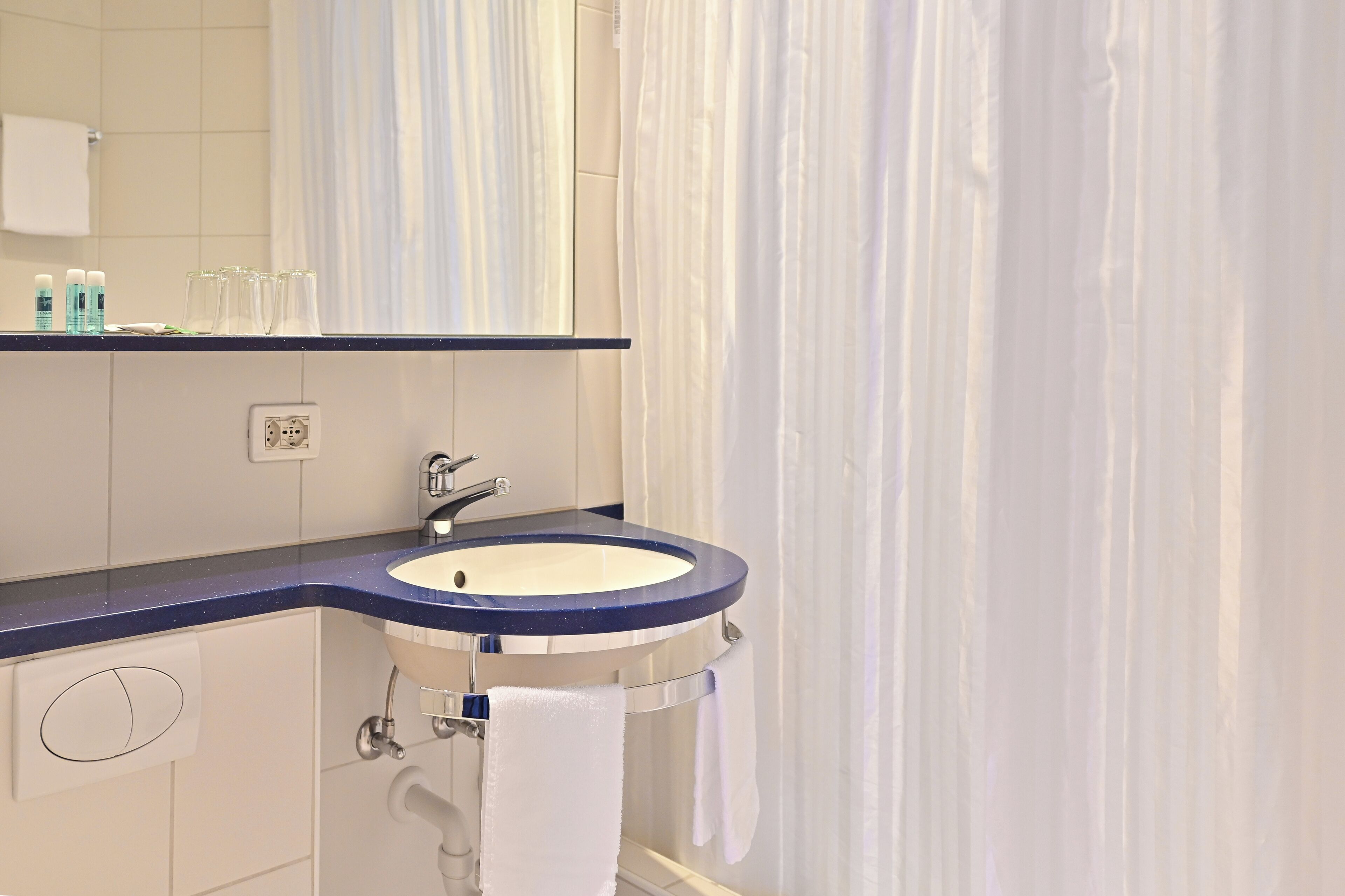A bathroom with a sink, mirror, and towel rack.