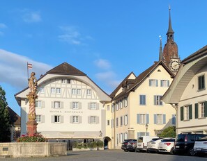 A historic building with a clock tower, a statue, and a sign for Hotel Zofingen. - Hotel Zofingen (Zofingen)