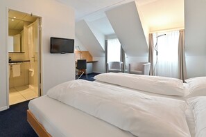 A hotel room with a bed, a desk, a chair, and a television. - Hotel Zofingen (Zofingen)