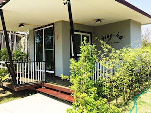 A building with a covered porch, a sign reading "king-ha coffee & house", and a small garden area with a bench.