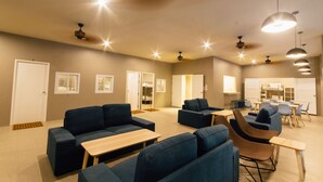 A spacious room with sofas, tables, and chairs arranged for socializing.