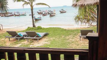Una mesa con alimentos para el desayuno y vistas a la playa con barcos.