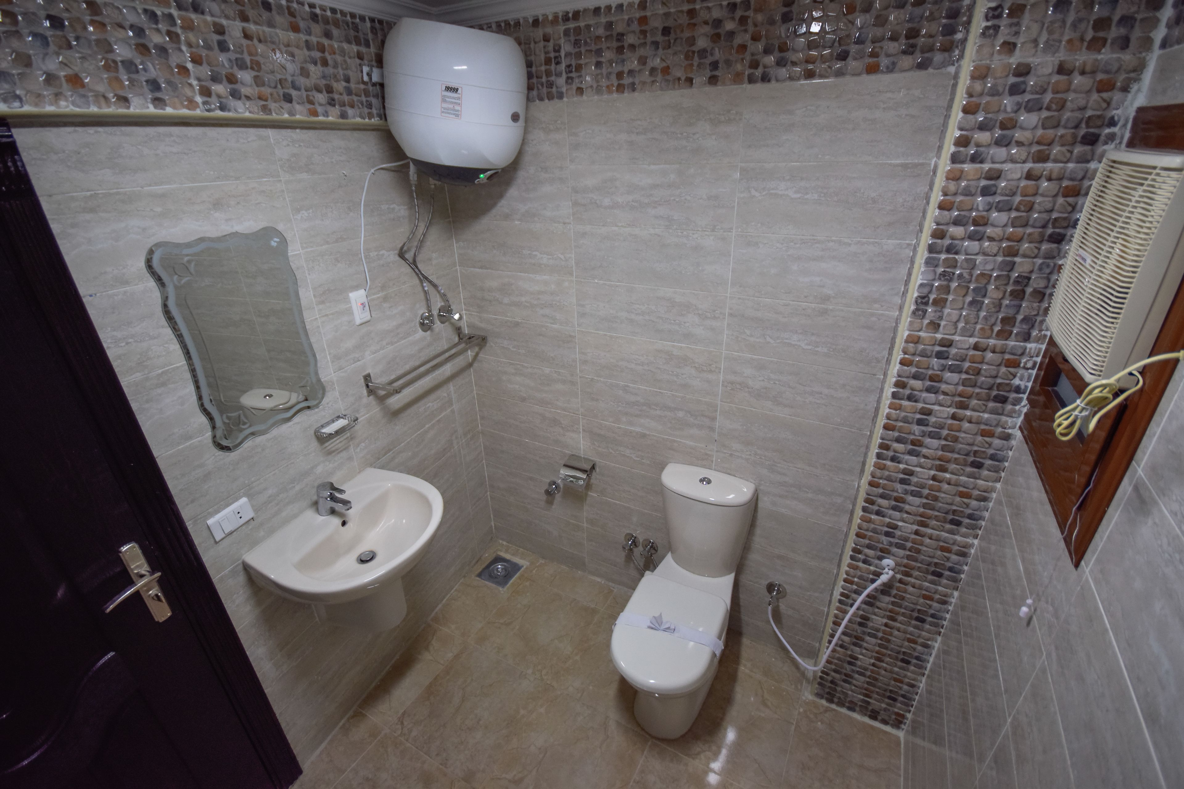 A bathroom with a toilet, sink, and towel rack.