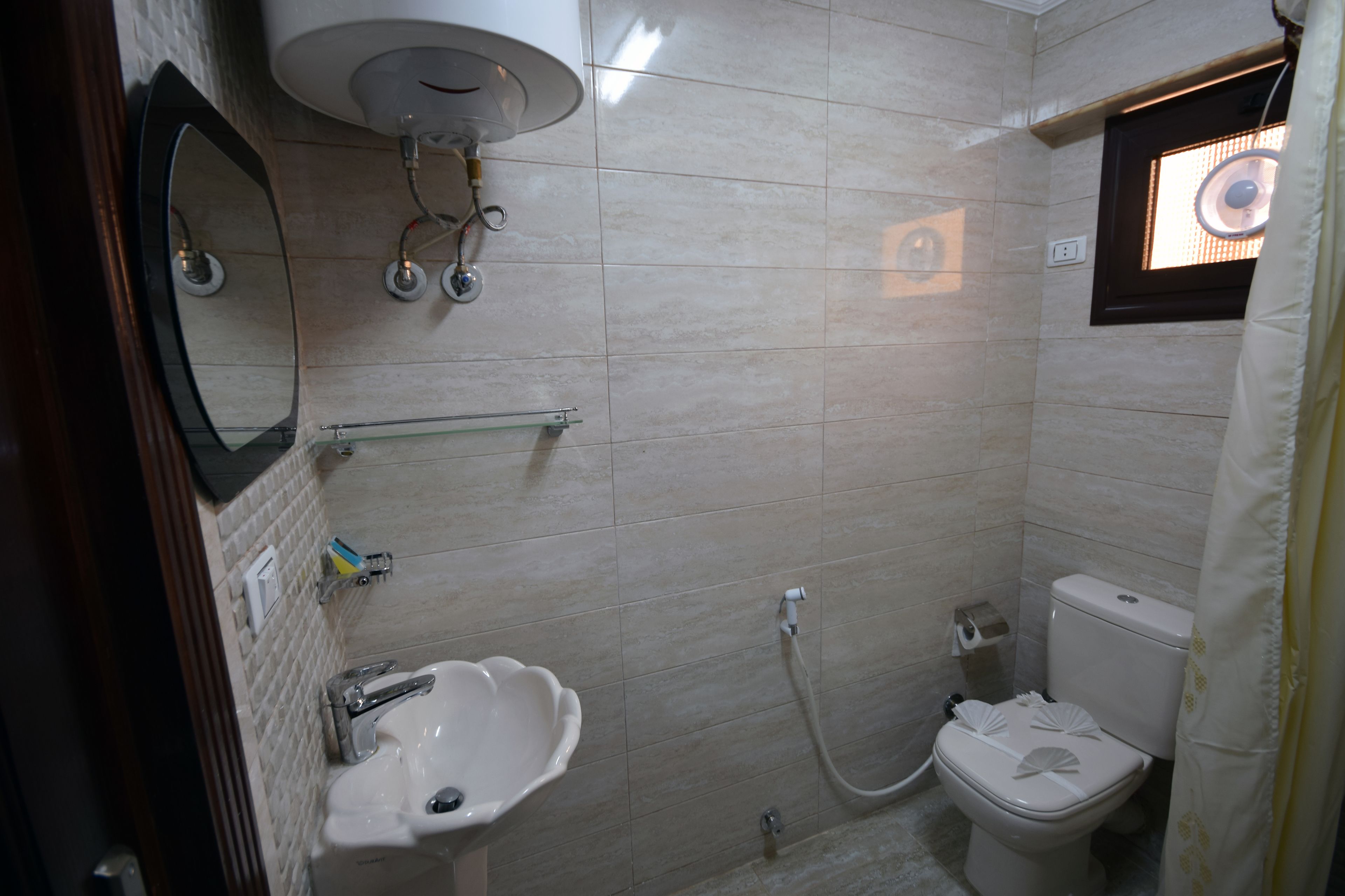 Une salle de bain équipée d’un lavabo, d’un miroir, de toilettes et d’une douche.