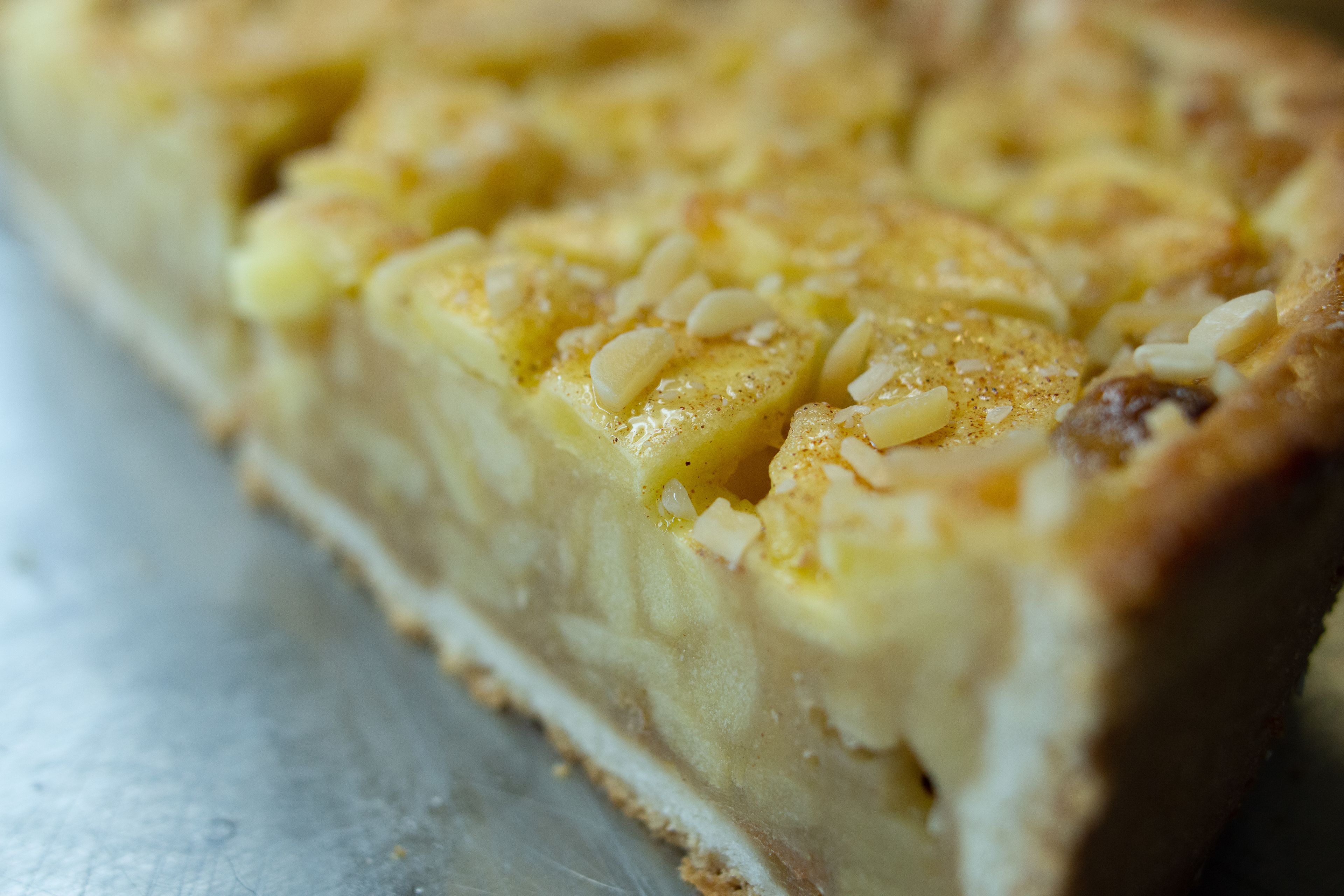 Une vue rapprochée d’un dessert à la croûte dorée, où l’on distingue des morceaux de fruits.