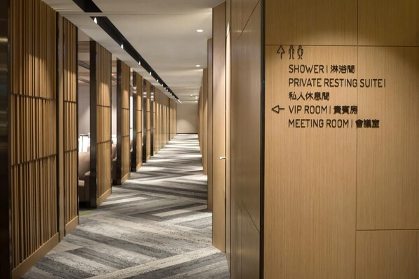 A hotel corridor with directional signs for a private resting suite, shower, VIP room, and meeting room.