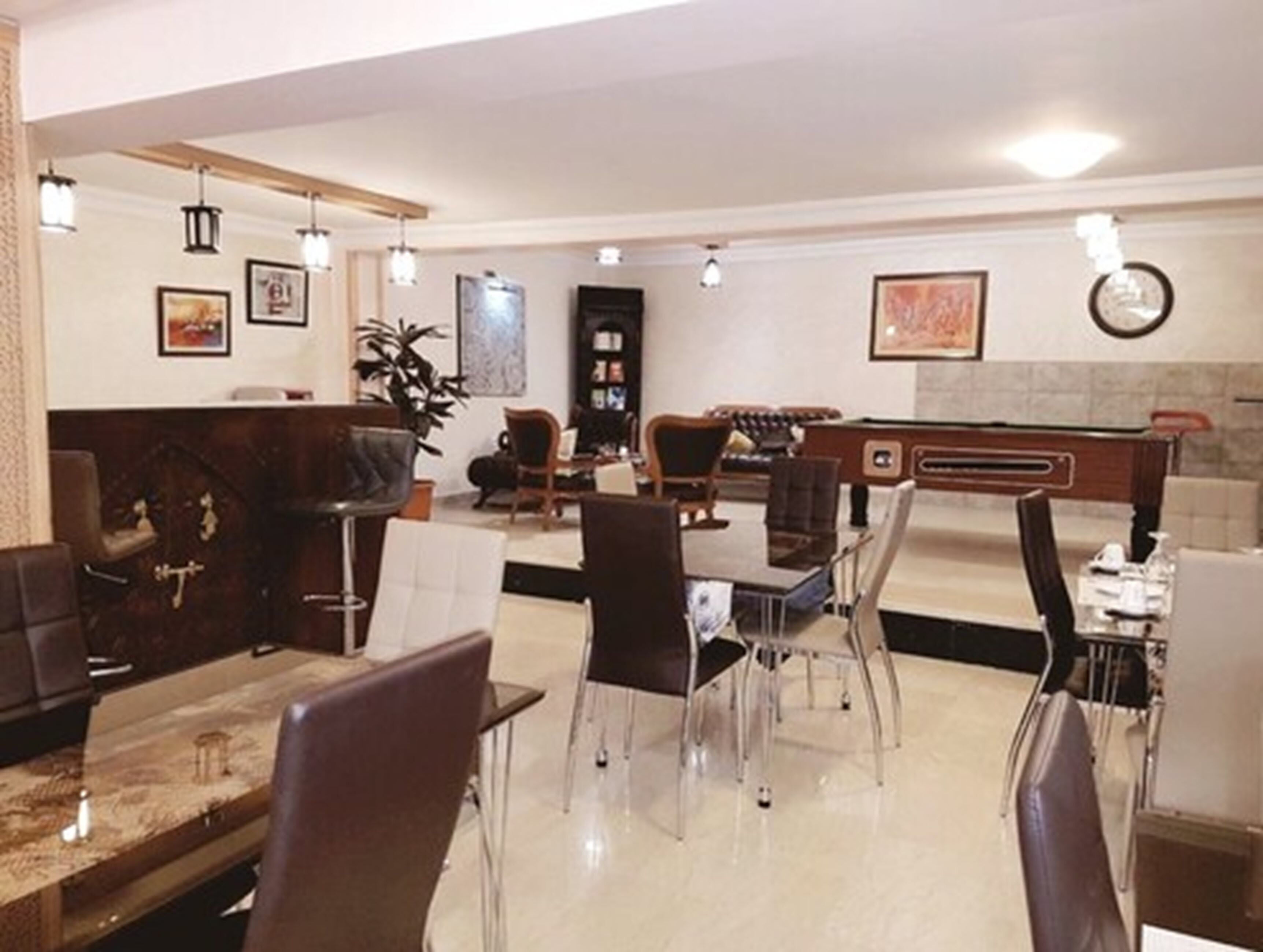 Una hall moderna di un hotel con reception, area salotto e bar.