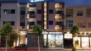 Un hotel con un cartel llamativo que dice "Lo Olivos Hotel Suites & Spa" y una entrada visible.