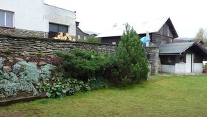 Zona residencial amb murs de pedra, gespa i cases d'arquitectura moderna i tradicional.