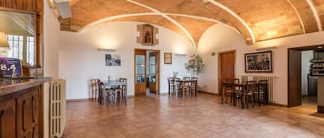 A spacious room with a high arched ceiling, wooden furniture, and a radiator.