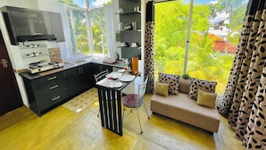 A modern kitchen with a dining area, large windows, and a cozy seating area. - 8 Plus Motels (Negombo)