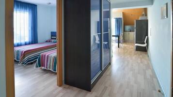 Habitación de hotel moderna con una cama grande, una zona de estar separada y vistas por una puerta corrediza.