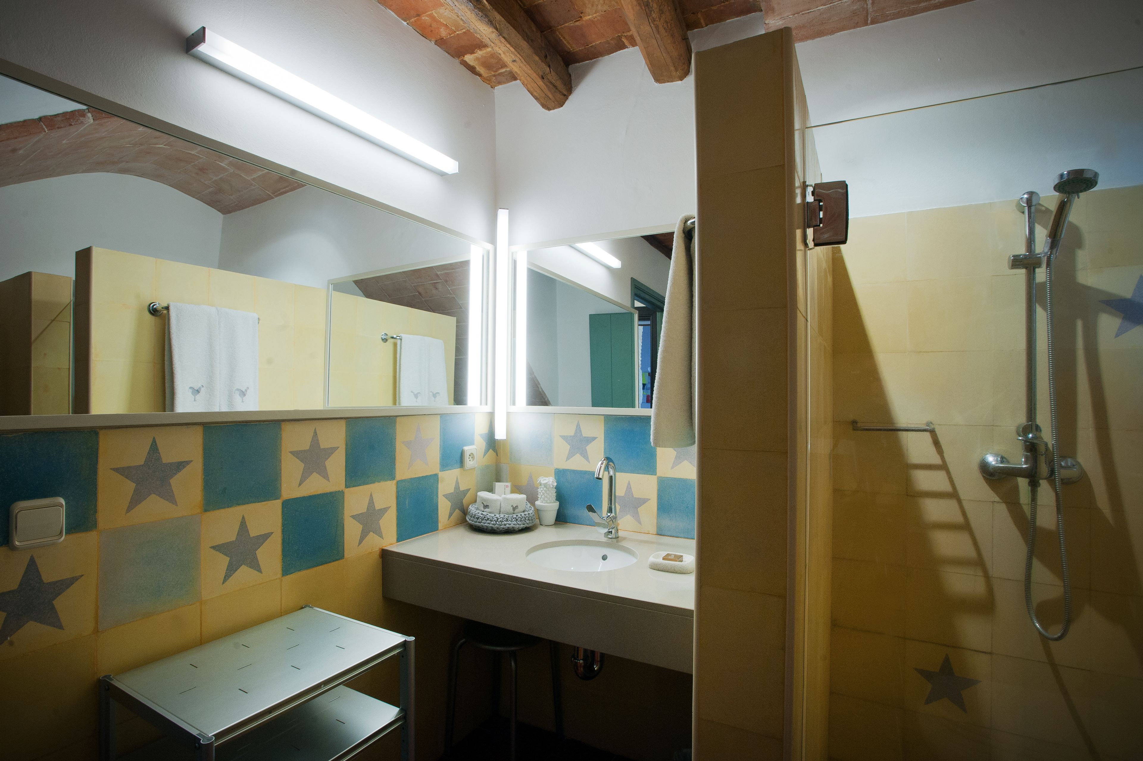 Une salle de bain avec un lavabo, un miroir et une douche.