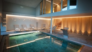 A modern indoor pool area with lounge chairs and a wooden wall. - Mas Falgarona Hotel Boutique and Spa (Avinyonet de Puigventos)
