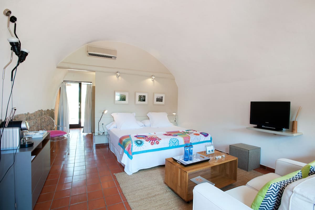 Une chambre d’hôtel moderne équipée d’un lit, d’une télévision, d’un bureau et d’un canapé.