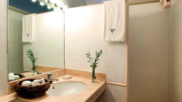 A bathroom with a sink, mirror, and two towels hanging on the wall.