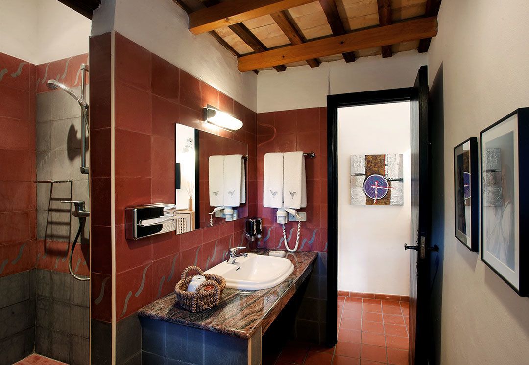 A bathroom with a shower, a sink with a towel rack, and a mirror.