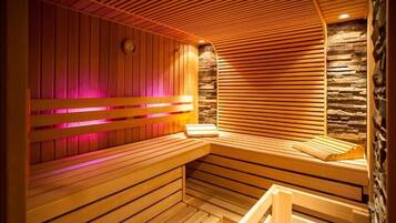 A sauna with wooden benches and slatted walls, a clock, and a stone wall.