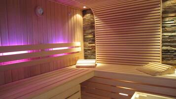 A sauna with wooden benches and a stone wall.