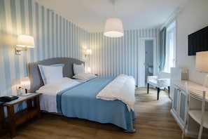 A hotel room with a bed, bedside lamps, a desk, and a chair. - Albergo Milano (Alta Valle Intelvi)