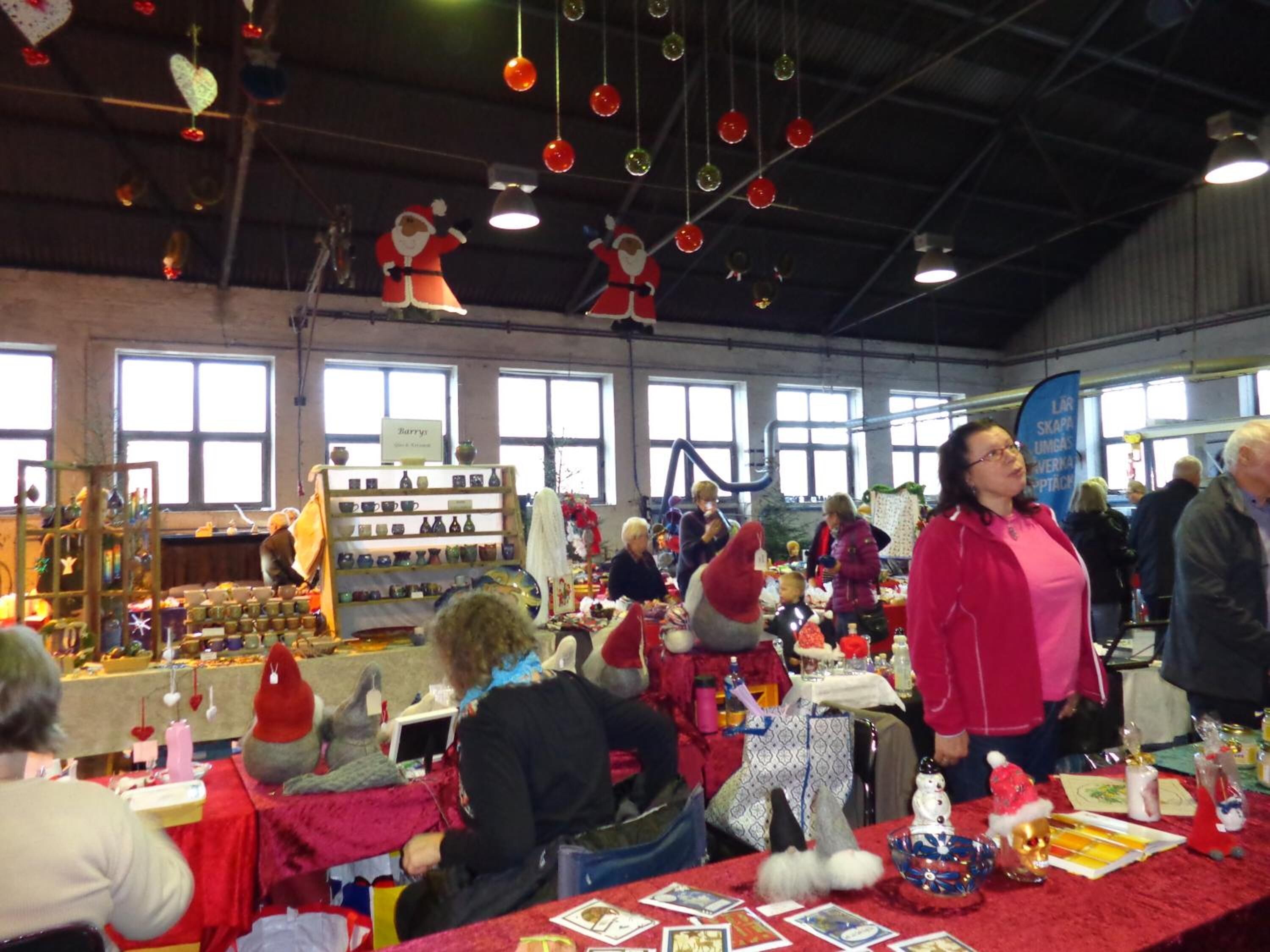 A market stall with various items on display, including ceramics and textiles.