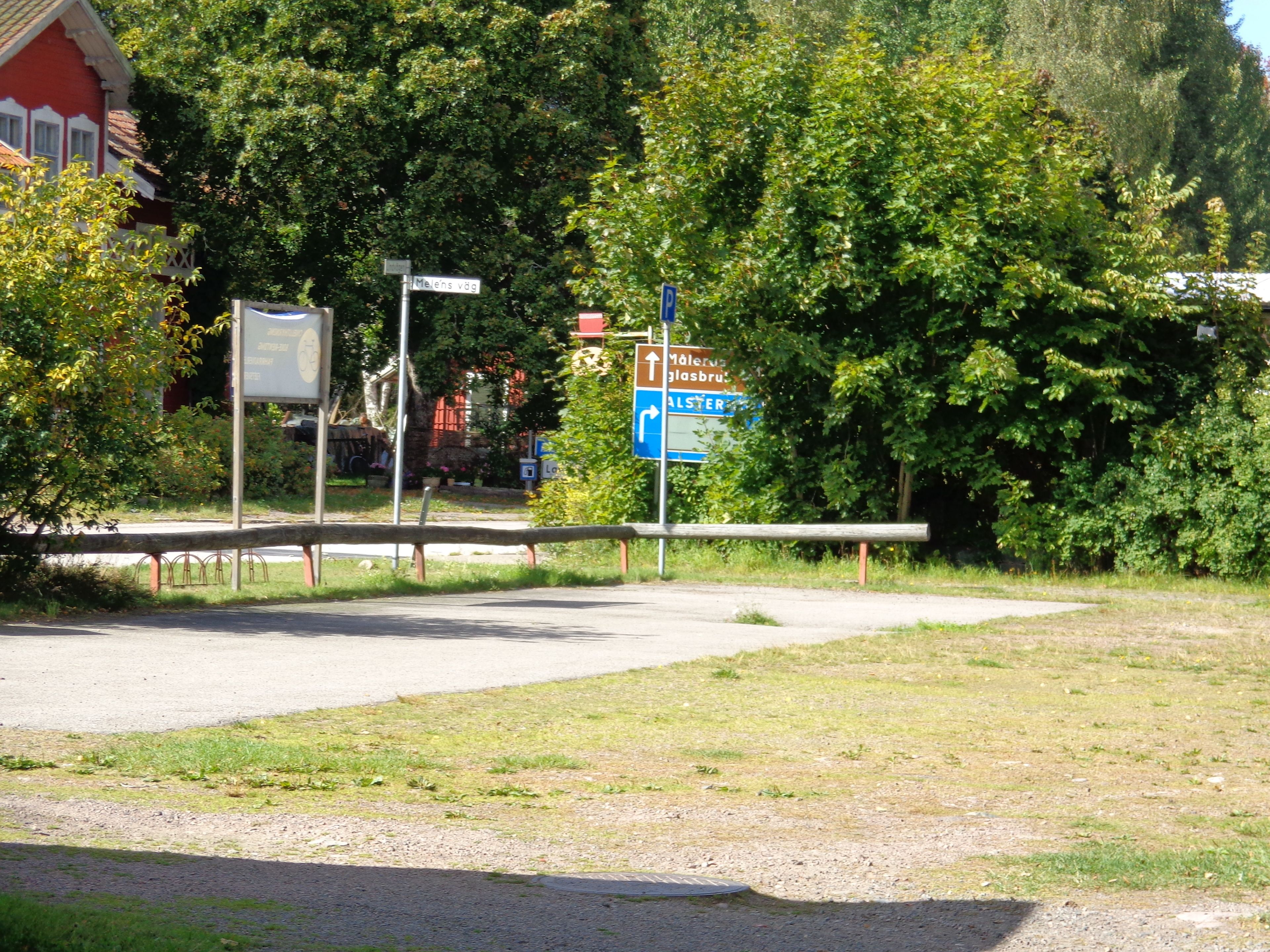 A parking area with a sign indicating directions to nearby locations.