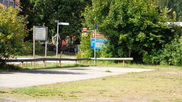 A parking area with a sign indicating directions to nearby locations.