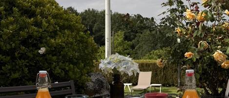 Disposición para comer al aire libre, con una mesa, comida, bebidas y un letrero al fondo.