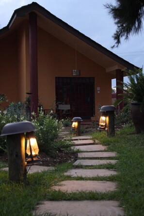 A building with a porch, a door, and a pathway leading to it.