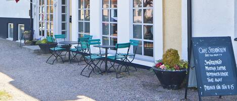 A hotel named "Hotel Spelabacken" with outdoor seating and a signboard listing breakfast options.