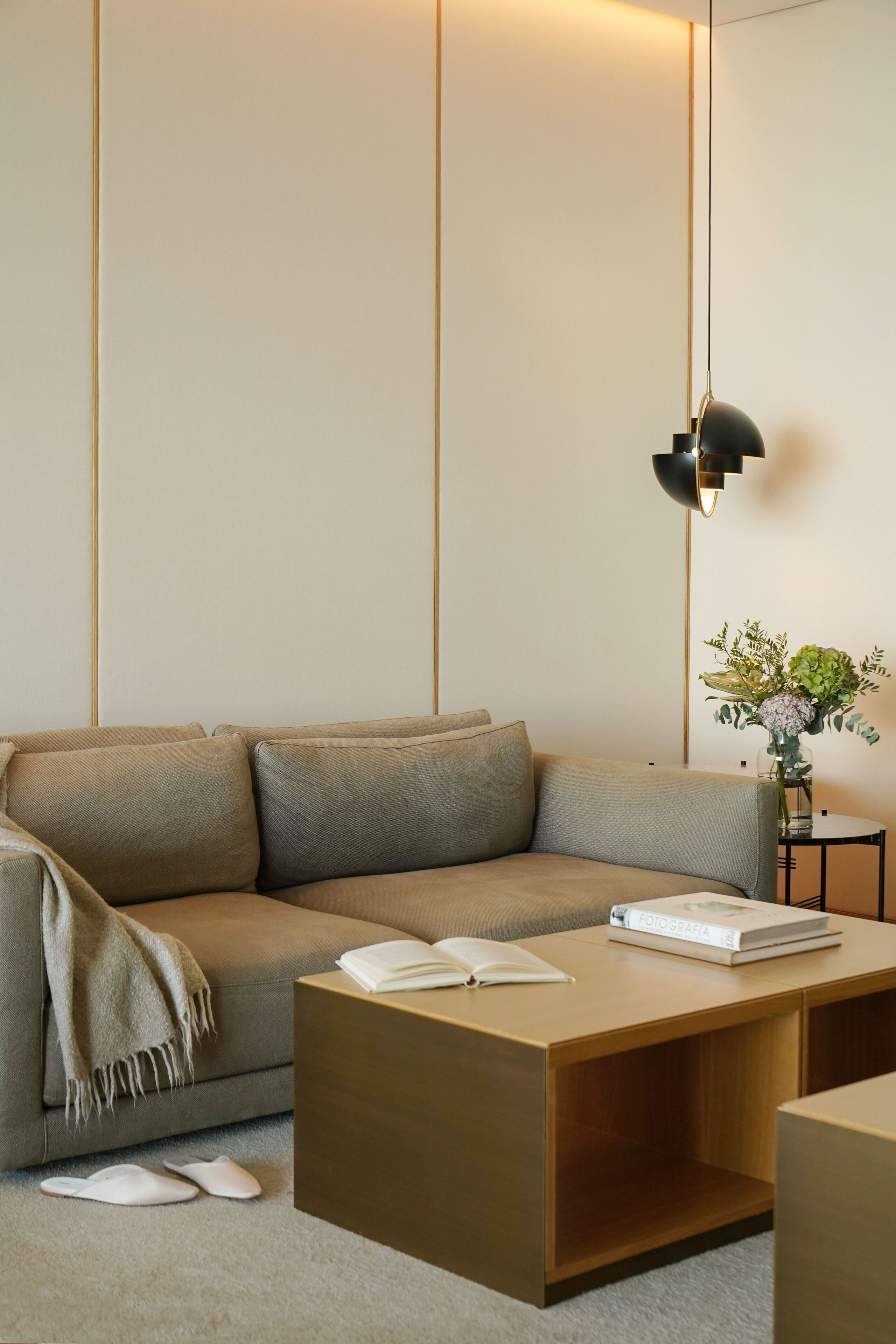 A modern living room with a sofa, coffee table, and a lamp.