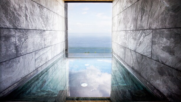 A modern interior with a view of the ocean through a glass floor. - Akelarre - Relais & Châteaux (San Sebastián)