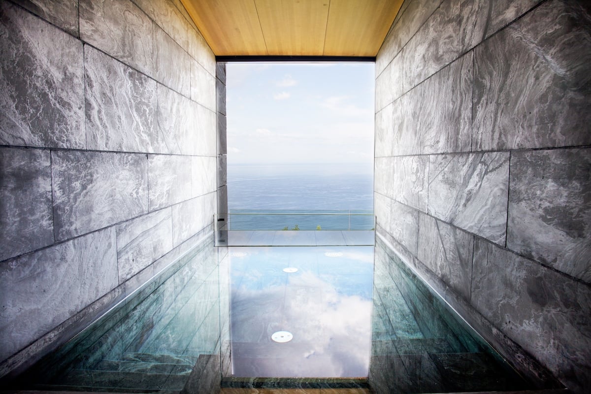 A modern interior with a view of the ocean through a glass floor.