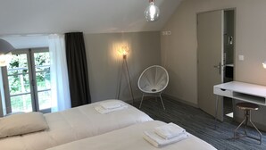 Een hotelkamer met een bed, een bureau, een stoel en een lamp.